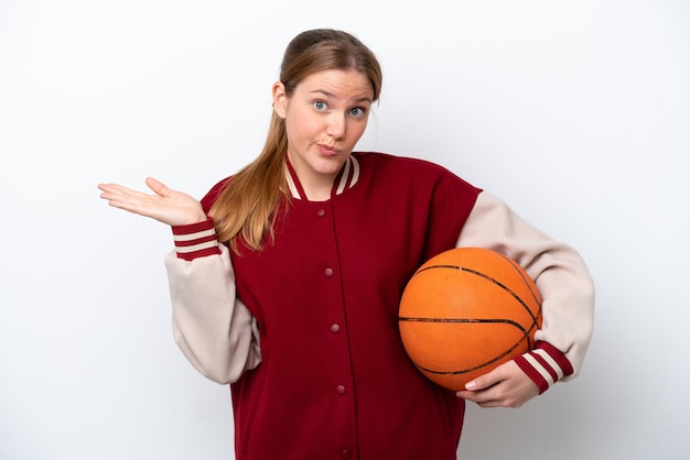 Jeune basketteur femme isolée sur fond blanc ayant des doutes tout en levant les mains