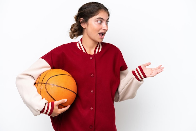 Jeune basketteur femme isolée sur fond blanc avec une expression surprise tout en regardant de côté