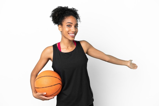 Jeune basketteur femme latine isolée sur fond blanc tendant les mains sur le côté pour inviter à venir