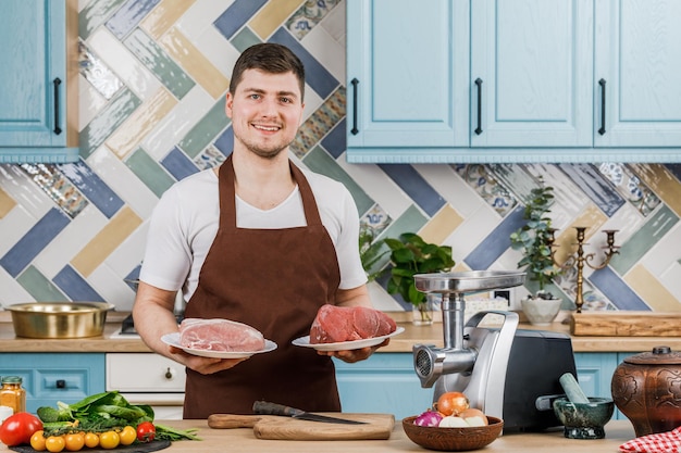 Le jeune beau chef masculin présente la nourriture dans la cuisine