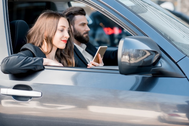 Jeune beau couple d'affaires conduisant une voiture dans la ville