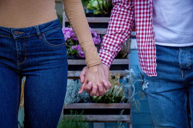 Jeune beau couple amoureux de bonne humeur se promène dans le parc en automne, main dans la main