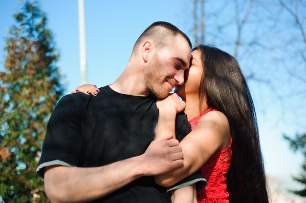 Jeune beau couple amoureux posant en plein air en ville. Jeune femme souriante avec son bel homme.