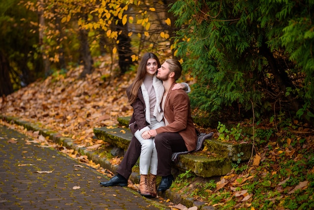 Jeune beau couple câlins dans le parc en automne.