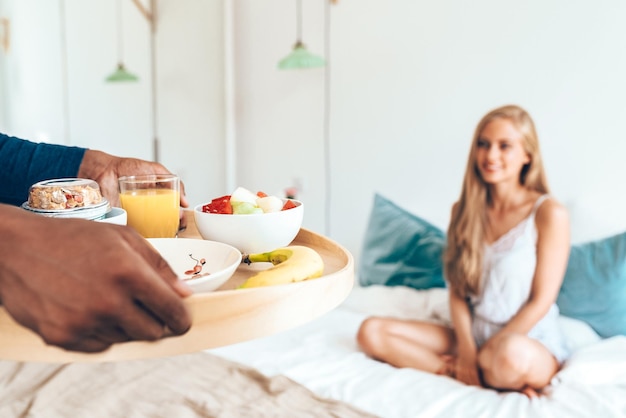 Jeune beau couple interracial ayant un petit déjeuner surprise au lit xA