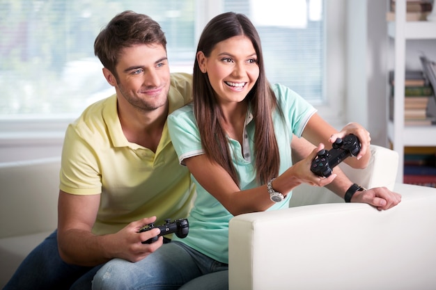 Jeune beau couple jouant au jeu vidéo
