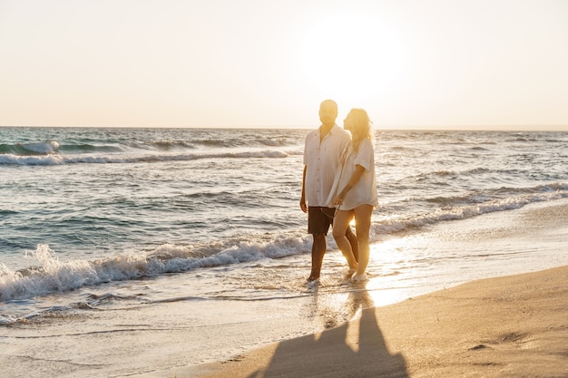 Jeune beau couple marchant sur la plage près de la mer