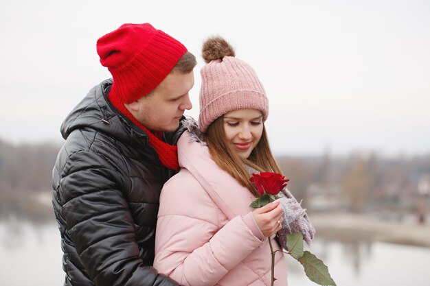 Jeune beau couple avec des roses rouges à l'extérieur