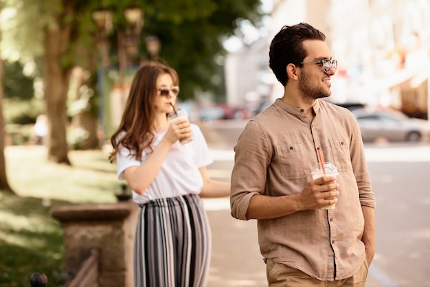 Jeune beau couple s'amuser et marcher dans les rues de la ville et boire du café