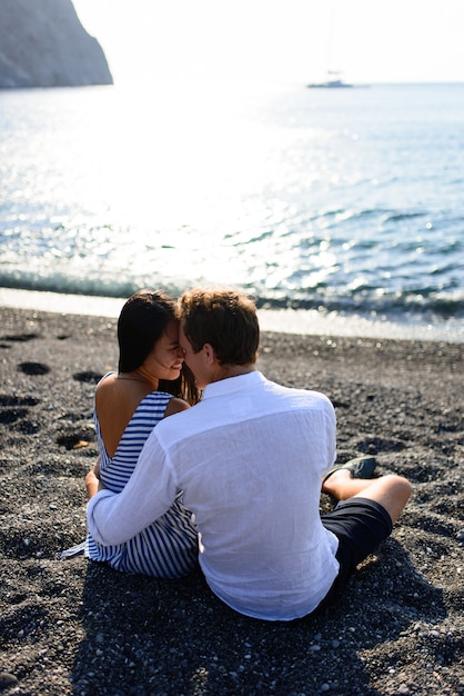 Jeune beau couple s'embrassant sur fond de mer.