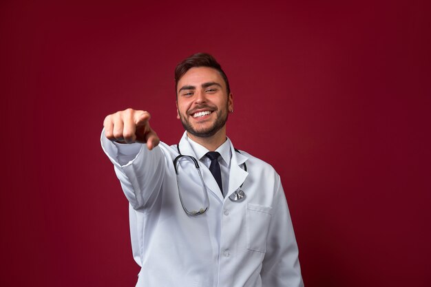 Jeune beau docteur caucasien sur fond rouge