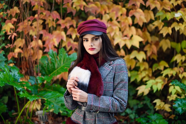 Jeune, beau, fille, à, cheveux très longs, porter, manteau hiver, et, chapeau, dans, automne feuilles, fond