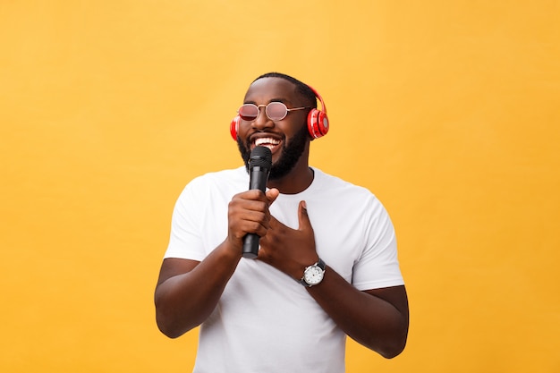 Jeune beau garçon afro-américain chantant émotionnel avec micro