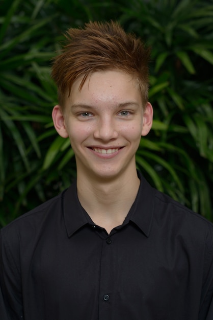 Photo jeune beau garçon aux cheveux blonds à l'extérieur