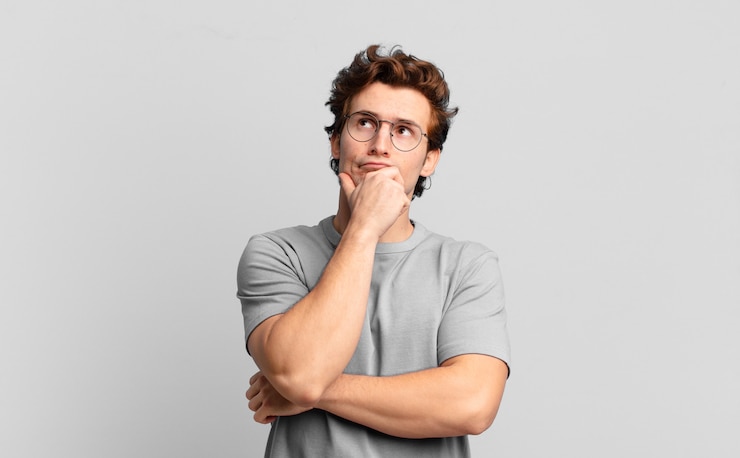 Photo jeune beau garçon pensant, se sentant dubitatif et confus, avec différentes options, se demandant quelle décision prendre