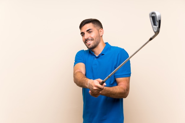 Jeune beau golfeur homme sur mur isolé