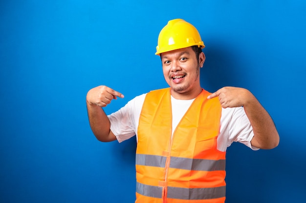 Jeune beau gros travailleur asiatique portant un gilet orange et un casque de sécurité