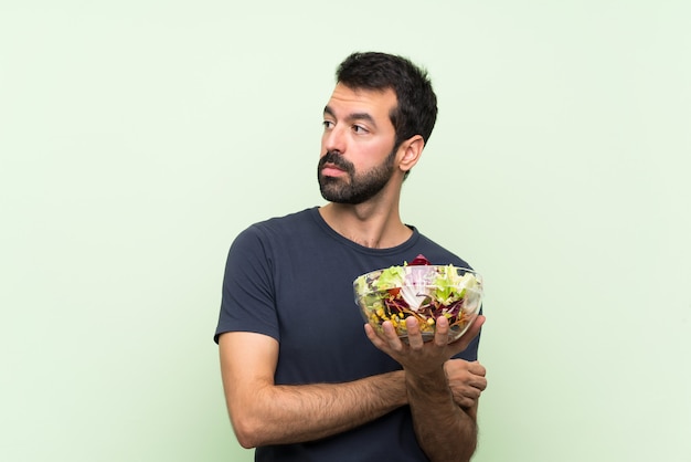 Jeune, beau, homme, à, salade, sur, mur vert, portrait