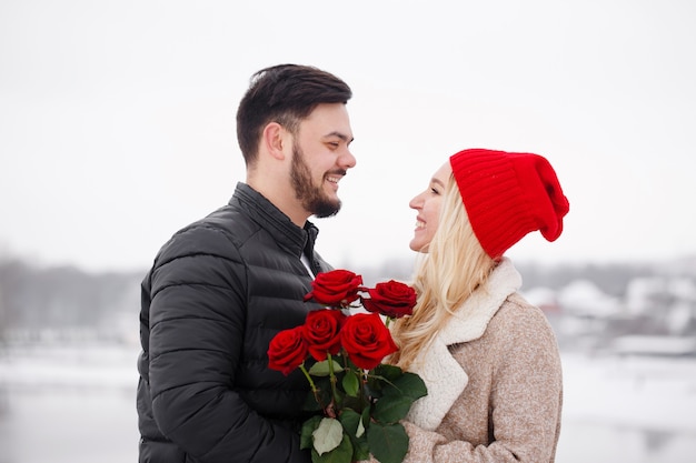 Jeune beau mec donnant à une femme un bouquet de roses le jour de la Saint-Valentin