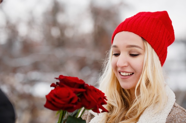 Jeune beau mec donnant à une femme un bouquet de roses le jour de la Saint-Valentin