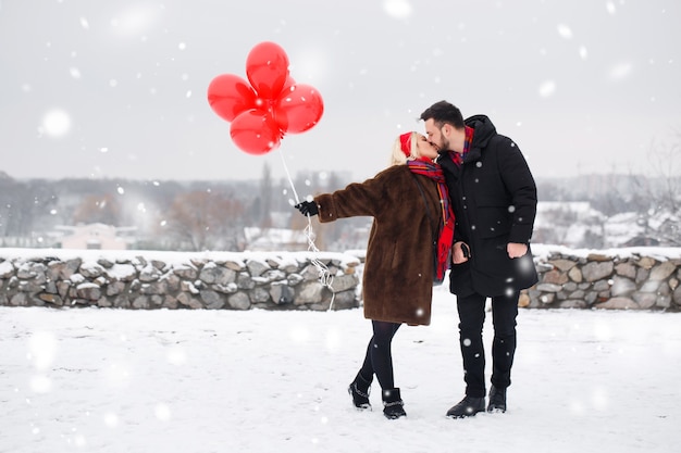 Jeune beau mec et fille avec des ballons marchant le jour de la Saint-Valentin