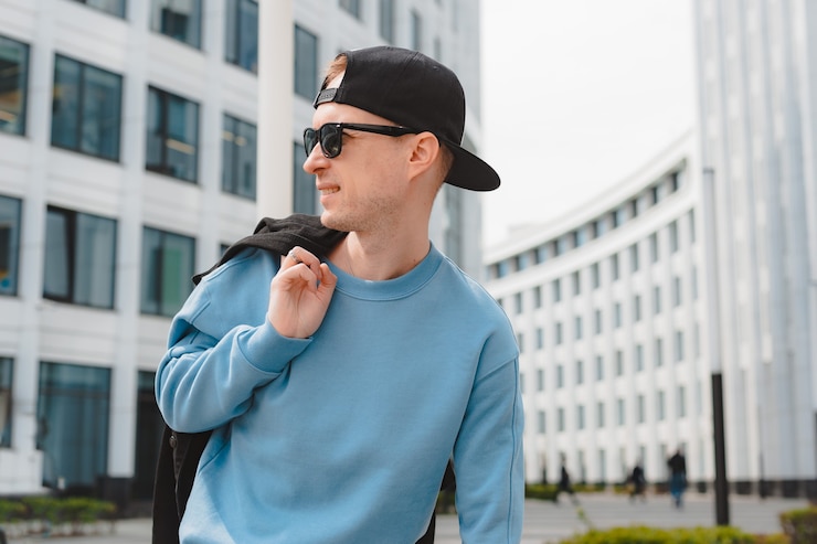 Photo jeune beau mec hipster à la mode gratuit marchant dans la rue, portant une casquette de lunettes de soleil