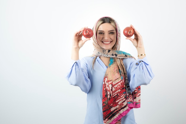 Jeune beau modèle en châle coloré posant avec des pommes rouges