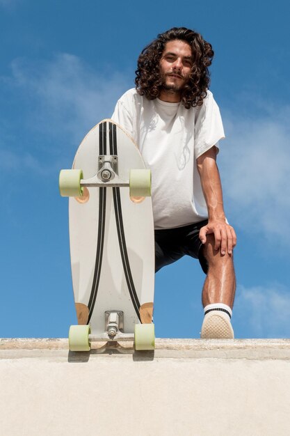 Jeune beau patineur caucasien en haut de la rampe de skate