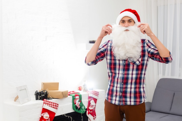 jeune beau père noël barbu avec longue barbe et chapeau de nouvel an, fond de noël