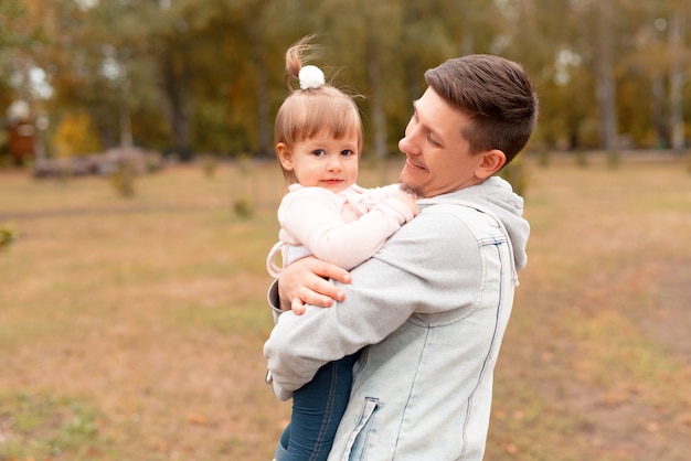 jeune beau père tenant dans les bras sa petite fille