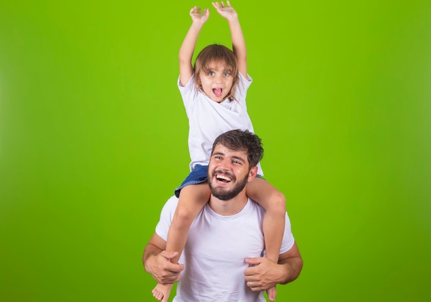 Jeune beau père tient sa fille autour du cou Père et fille en arrière-plan studio avec copie espace Bonne fête des pères