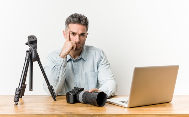 Jeune, beau, prof de photographie, pointant le temple avec le doigt, pensant