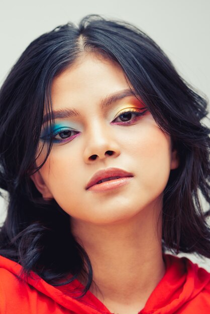 Jeune beau visage. Jolie femme modèle avec maquillage mode sur fond gris