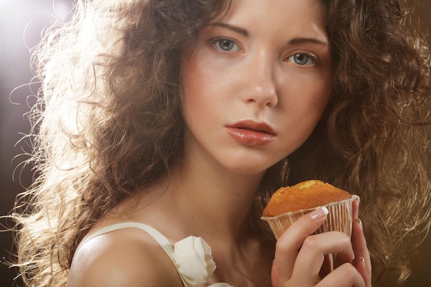 Jeune beauté bouclée fille avec gâteau temps heureux