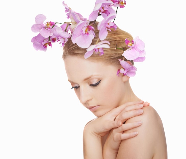 Jeune beauté en fleurs Superbe jeune femme sur fond blanc avec des orchidées roses dans les cheveux