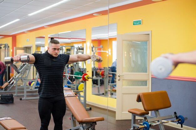 Jeune bel athlète dans la vieille salle de gym rouillée