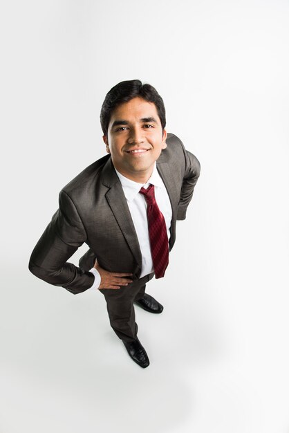 Jeune et bel homme d'affaires asiatique indien en tenue de rasage et de bureau debout, regardant la caméra ou dans le ciel, une vue de dessus également connue sous le nom de vue à vol d'oiseau montrant la perspective