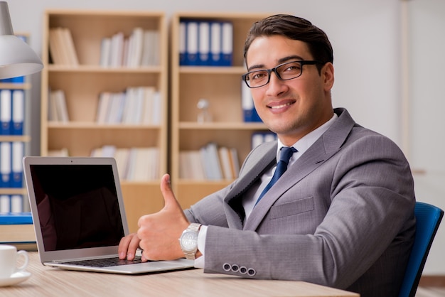 Jeune bel homme d&#39;affaires travaillant au bureau