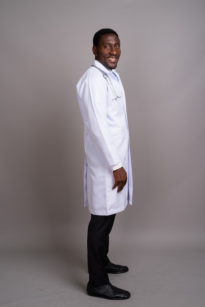 Jeune bel homme africain médecin sur fond gris