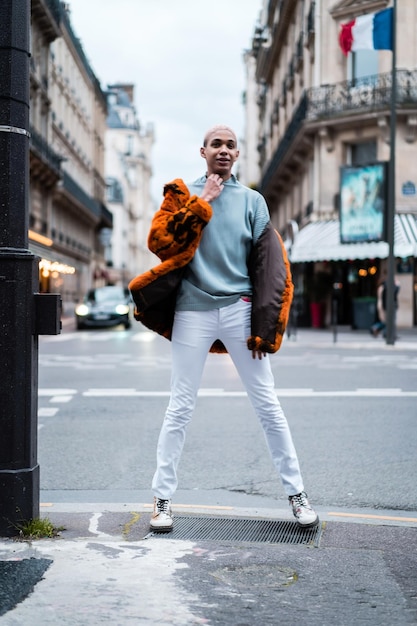 Jeune bel homme afro-américain posant à l'extérieur à Paris. sourire heureux, style de mode.