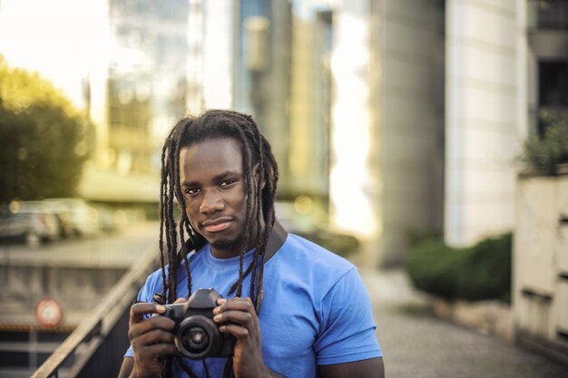 Jeune bel homme afro avec une caméra