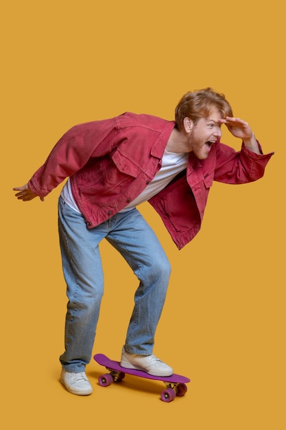 Jeune bel homme à l'aide de skateboard