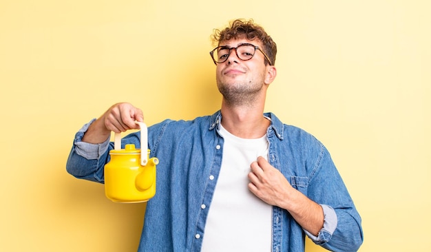 Jeune bel homme à l'air arrogant, réussi, positif et fier. concept de théière