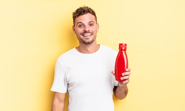 Jeune bel homme à l'air heureux et agréablement surpris. concept de ketchup