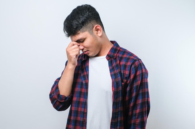 Jeune bel homme asiatique avec la main sur la tête pour la douleur dans la tête parce que le stress souffre de migraine