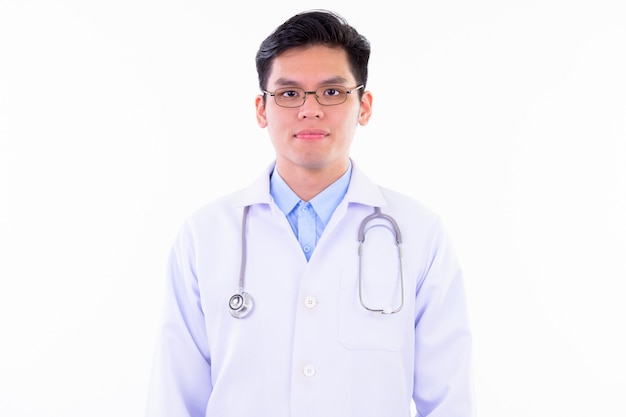 Jeune bel homme asiatique médecin avec des lunettes isolé contre un mur blanc