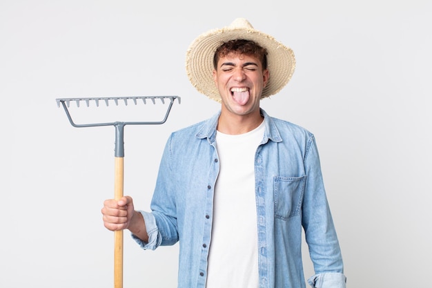 Jeune bel homme avec une attitude joyeuse et rebelle, plaisantant et tirant la langue. concept d'agriculteur