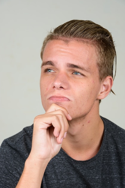 jeune bel homme aux cheveux blonds contre blanc