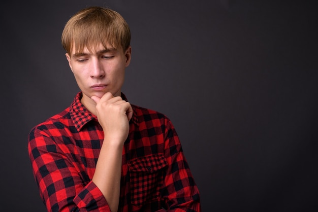 Jeune bel homme aux cheveux blonds pensant