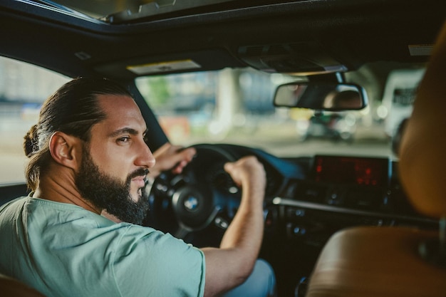 Jeune bel homme aux cheveux bruns tenant un volant